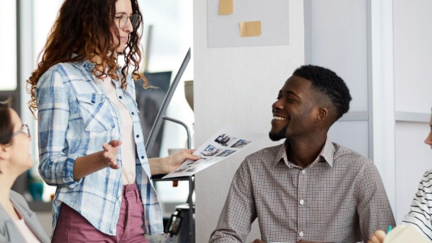 Diverse coworkers from different age groups enjoying each other's company in a collaborative workspace.