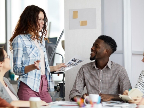 Diverse coworkers from different age groups enjoying each other's company in a collaborative workspace.