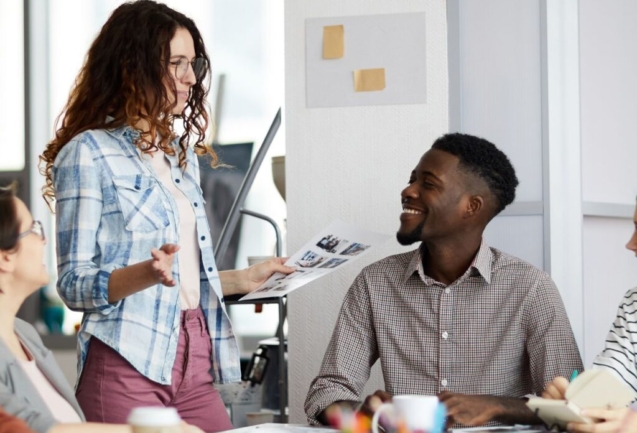 Diverse coworkers from different age groups enjoying each other's company in a collaborative workspace.