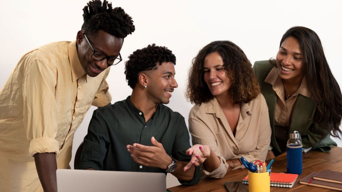 Young, diverse team collaborating on a project, with everyone engaged in active conversation.