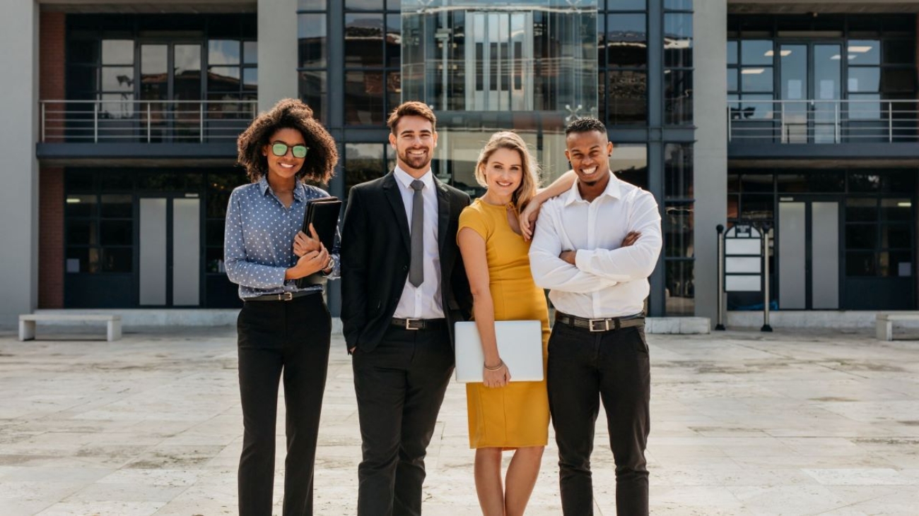 Diverse team members smiling and standing outside office