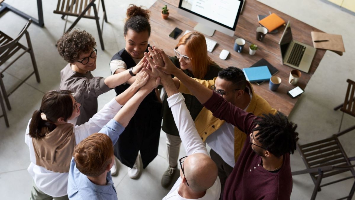 A picture of employees joining hands to accomplish a particular task.